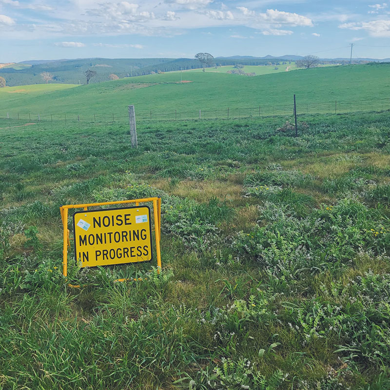 Noise monitoring in progress sign in a field - acoustic engineer concept